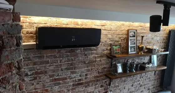klimatyzator czarny zamontowany w mieszkaniu na ceglanej ścianie